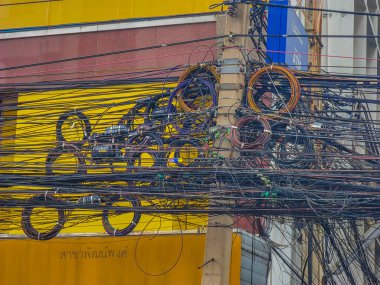 A tangle of wires on electricity poles in the streets of Bangkok, Thailand