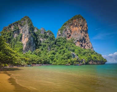 Tayland 'ın Krabi bölgesindeki Railay Batı Sahili. Çevresinde altın kum ve yeşil dağlar olan cennet kumsalı.