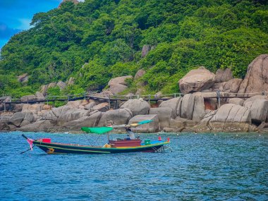 Tayland 'ın Koh Tao şehrindeki Koh Nang Yuan cennet adasının önündeki geleneksel Tayland teknesi. Yaklaşan gemiden denizden fotoğraf