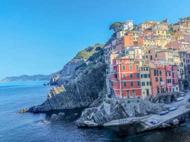 Riomaggiore şehrinin havadan panoramik manzarası. Bir sürü renkli evi ve akşamları Cinque Terre 'de küçük tekneleri olan körfez manzarası.