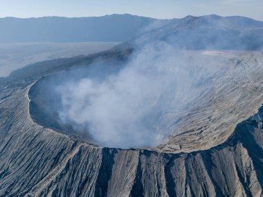 Bromo volkan kraterinin hava manzarası, duman geliyor. Doğu Java, Endonezya 'daki Tengger Semeru Ulusal Parkı' nda aktif bir volkan..