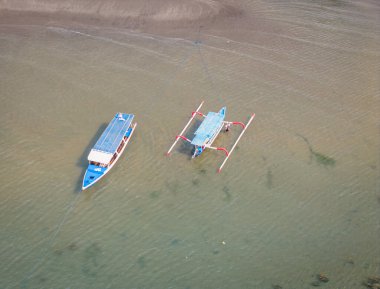 Batı Nusa Tenggara, Endonezya 'daki Lombok adasındaki sahilde duran geleneksel Endonezya balıkçı teknelerinin hava manzarası.