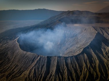 Bromo volkan kraterinin hava manzarası, duman geliyor. Doğu Java, Endonezya 'daki Tengger Semeru Ulusal Parkı' nda aktif bir volkan..
