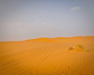 Sahra Çölü 'nde, Merzouga' da, Fas 'ta, Kuzey Afrika' da araba izleri olan güzel kum tepeleri.