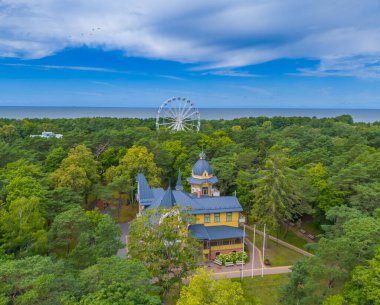 Palanga şehir müzesi, Litvanya. Baltık deniz tatil köyünün insansız hava aracı görüntüsü. Dönme dolap ve ufukta deniz olan güzel bir yaz sahnesi.