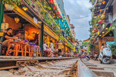 Hanoi, Vietnam - 04: 30 2023: Hanoi tren yolu Vietnam 'da. Hanoi Eski Mahallesi 'nin dar bir sokağında trenler evlerden geçiyor..