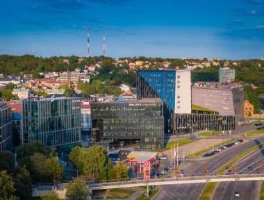 Kaunas, Litvanya - 08 06 2024: Nemunas Nehri kıyısındaki bir gökdelen ve modern ofis binalarıyla Kaunas şehir merkezinin insansız hava aracı görüntüsü
