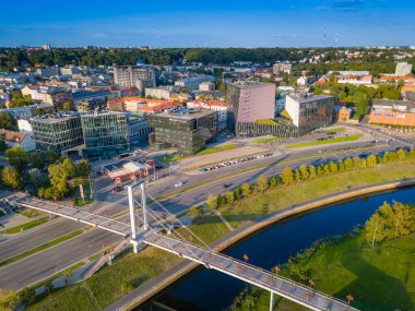 Kaunas, Litvanya - 08 06 2024: Nemunas Nehri kıyısındaki bir gökdelen ve modern ofis binalarıyla Kaunas şehir merkezinin insansız hava aracı görüntüsü