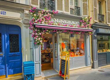 09 25 2024 - Paris, Fransa. Bir Paris mağaza vitrininin dış cephesi, mağaza önü şablonu, çiçeklerle dolu bir dükkan penceresi ve diğer renkli elementler