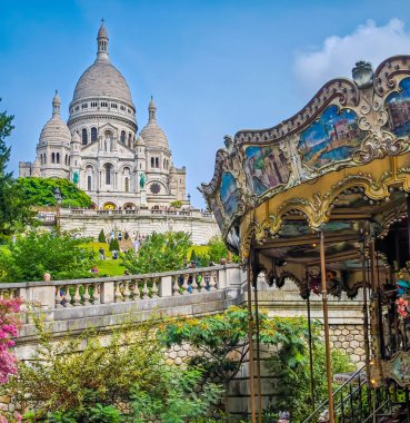 09 25 2024 - Paris, Fransa. Basilique Du Sacre Coeur de Montmartre ile renkli bir atlıkarınca. Kutsal Yürek Kilisesi 'nin yakın fotoğrafını çek.