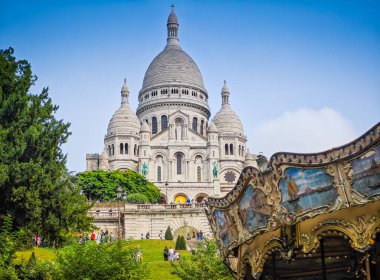 Basilique Du Sacre Coeur de Montmartre ile renkli bir atlıkarınca. Paris, Fransa 'da kutsal kalp ikonik beyaz kubbeli kilisenin yakın fotoğrafı.