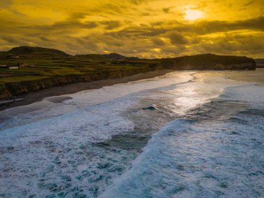 Santa Barbara plajı volkanik kum ve turkuaz Atlantik okyanus dalgalarıyla Sao Miguel, Azores 'de. Ribeira Grande 'deki sahil manzaralı hava günbatımı