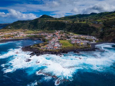 Mosteiros kasabası. Azores, Sao Miguel adasındaki köyün insansız hava aracı görüntüsü. Büyük turkuaz dalgalar ve dağlarla Atlantik Okyanusu kıyısında yer alıyor.