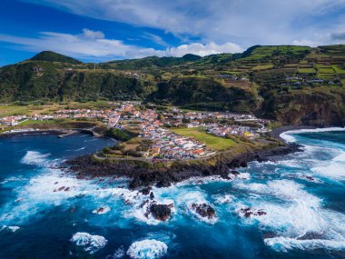 Mosteiros kasabası. Azores, Sao Miguel adasındaki köyün insansız hava aracı görüntüsü. Büyük turkuaz dalgalar ve dağlarla Atlantik Okyanusu kıyısında yer alıyor.