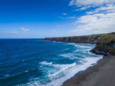 Kara kum plajlı Azores adalarının hava aracı görüntüsü. Portekiz, Sao Miguel 'de Praia dos Moinhos manzarası. Uçurumlarla dolu Atlantik Okyanusu kıyısı