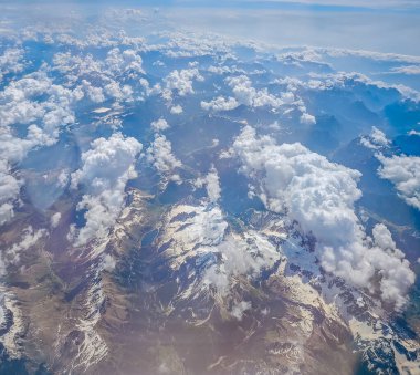 Alpler uçak penceresinden. Pencereden gelen karlı dağlar. Hava görünümü