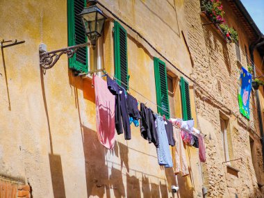 Volterra, Tuscany. Street view of Volterra with laundry outside the window - medieval Tuscan town located on a hill with old town clipart