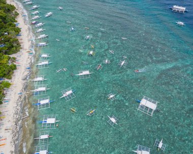 03 24 2025 - Balicasag Adası Panglao Bohol, Filipinler. Geleneksel Filipinler tekneleriyle ıssız adanın panoramik drone görüntüsü