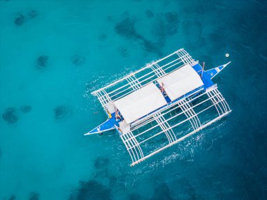 Geleneksel Filipinler adasının turkuaz renkli teknesine yakın. Havadan görünüşlü drone fotoğrafı