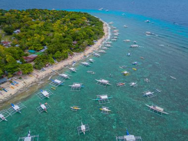 03 24 2025 - Balicasag Adası Panglao Bohol, Filipinler. Geleneksel Filipinler tekneleriyle ıssız adanın panoramik drone görüntüsü