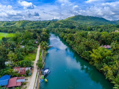Filipinler 'deki Bohol adasında palmiye ağaçları olan Loboc Nehri. Nehir seyahatleri için popüler olan insansız hava aracı görüntüsü 