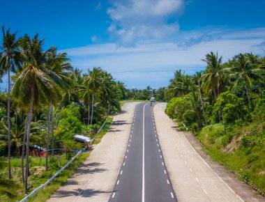 Filipinler 'deki Palawan Adası' nda El Nido 'ya uzanan egzotik palmiye ağacı yolu. Hava aracı fotoğrafı. Puerto Princesa 'dan El Nido' ya açık yol gezisi 