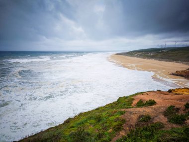 Portekiz, Nazare 'de dev dalgalar çarpıyor. Farol da Nazare 'deki dünyanın en büyük dalgalı plajı. Sörf için turistik bir yer. Dalgalı okyanus. 