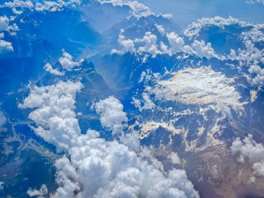 Alpler uçak penceresinden. Pencereden gelen karlı dağlar. Hava görünümü