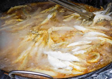 Litvanya 'nın Palanga kentindeki Stintu festivalinde büyük bir kızartma tavasında kızartılmış balık. Çıtır ekmekli Avrupa balığı yağda eridi.