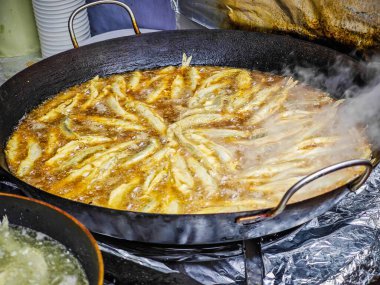 Litvanya 'nın Palanga kentindeki Stintu festivalinde büyük bir kızartma tavasında kızartılmış balık. Çıtır ekmekli Avrupa balığı yağda eridi.
