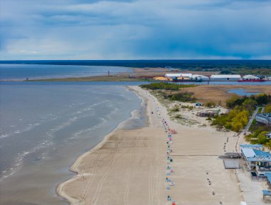 Deniz kenti Parnu 'nun havadan görünüşü. Baltık deniz kıyısındaki Estonya tatil köyünün kumlu plajlı insansız hava aracı görüntüleri. 