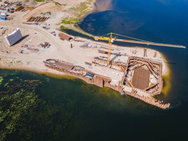 Litvanya, Kaunas 'ta yeni modern köprü inşaatı şantiyesi. Nehrin iki kıyısını birbirine bağlayan köprünün insansız hava aracı görüntüsü. Çalışma süreci