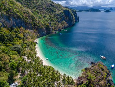 El Nido, Palawan, Filipinler 'de yedi komando plajı. Hava aracı görüntüsü. Beyaz kum ve palmiyeleri olan turkuaz güzel bir sahil manzarası.