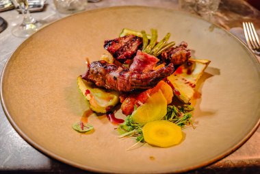 Lamb cut grilled and served with a side dish on a stylish plate at a luxurious restaurant
