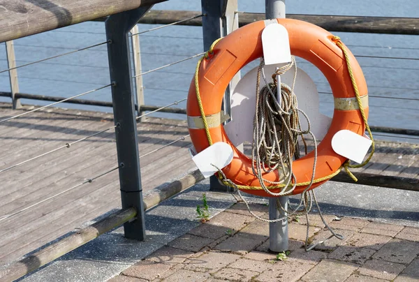 Red buoy life safety ring on post at riverbank uk