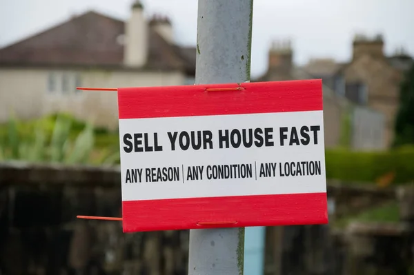 Sell your house fast sign outside residential area during property crisis UK