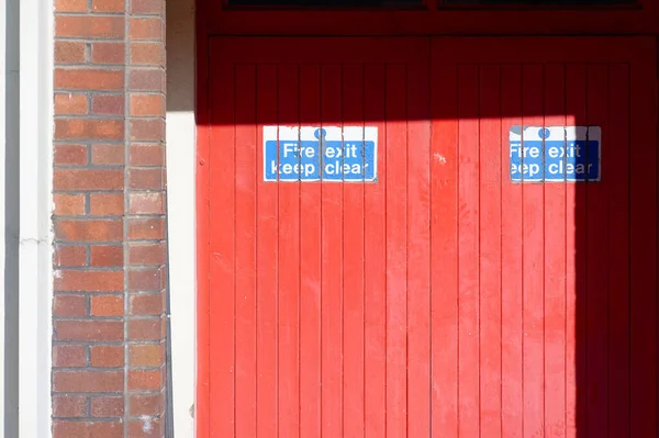 Fire exit keep clear sign on construction building site door UK
