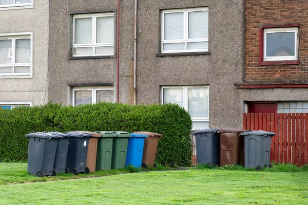 stock image Wheelie bins in row for refuge collection outside council residential building UK