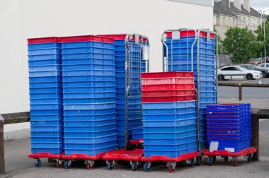 Araba parkındaki süpermarketin önüne istiflenmiş plastik paletler.