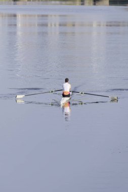 Adam sabahın erken saatlerinde İngiltere nehrinde kürek çekmek için kanoda antrenman yapıyor.