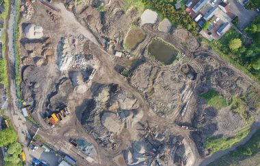 Taş ocağı endüstriyel kazılarda çalışıyor. Yukarıdan kumları ve tepeleri gösteren hava manzarası var.