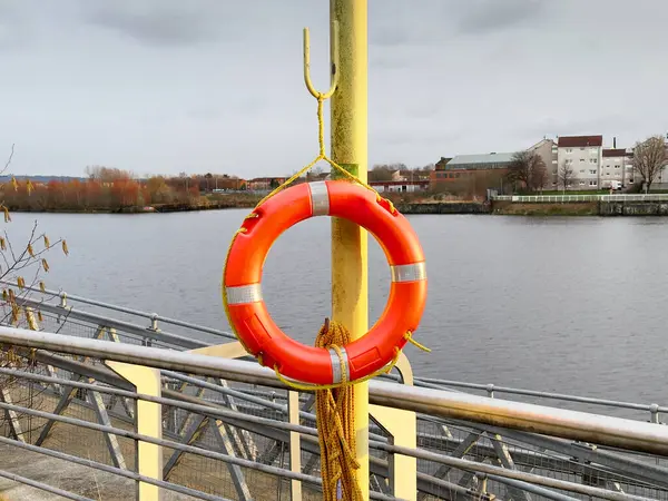 Red buoy life safety ring on post at riverbank in Glasgow UK