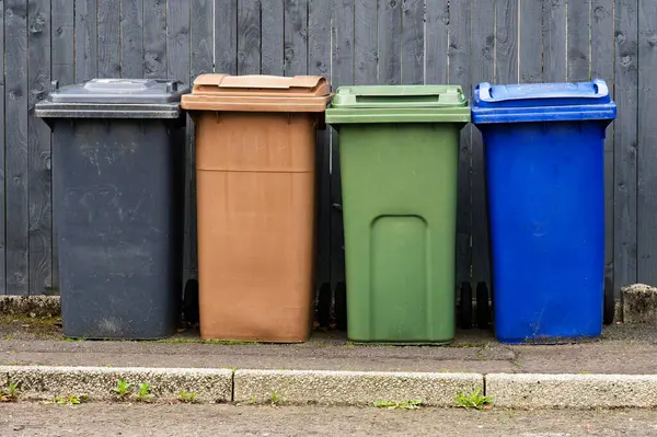 Wheelie bins in row segregated for recycling rubbish UK