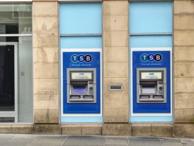 Şehir merkezindeki bankanın dışındaki duvarda para makinesi var.