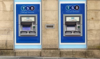 Şehir merkezindeki bankanın dışındaki duvarda para makinesi var.