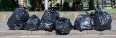 Siyah plastik torbalar ağzına kadar dolu ve İngiltere 'de toplanması için sokağa bırakılmış.