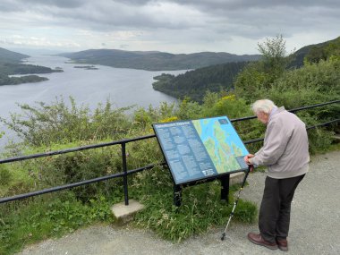 Tighnabruaich, Scotland, UK, August 6th 2024, Senior tourist at the Tighnabruaich viewpoint overlooking Isle of Bute and Colintraive clipart