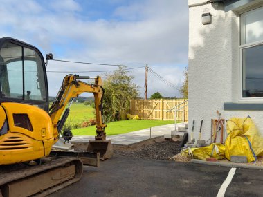 Garden renovation works with new lawn and paving slabs UK clipart