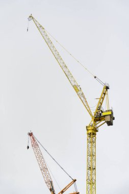 Tower crane high in sky at construction site UK clipart