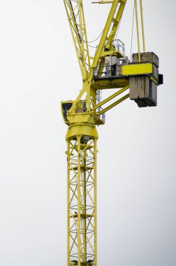 Tower crane high in sky at construction site UK clipart